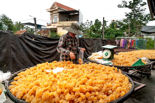 A person packaging freshly made jaggery at an outdoor rural farm setting.