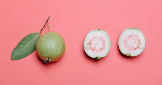 Whole and cut guava with leaf on pink background. Perfect for healthy eating concepts.
